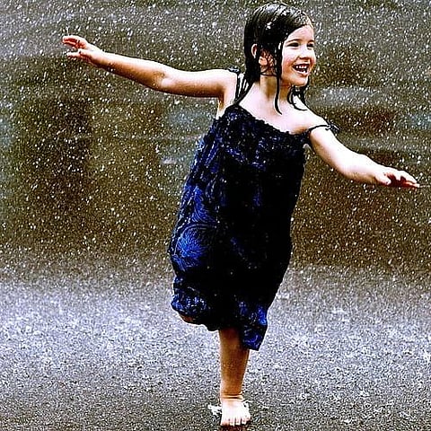 Goa : A girl having fun in the rain
