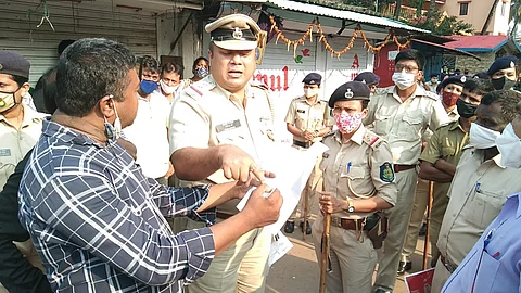 बायणा येथे वास्कोचे पोलीस निरीक्षक नीलेश राणे यांच्याशी हुज्जत घालताना दुकानदार