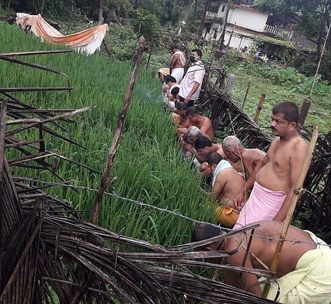 शेतीचे पूजन करताना पुजारी.