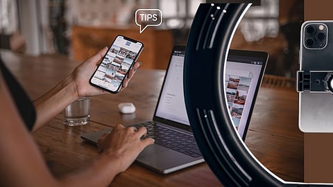 Lady working on a laptop, with ring light and mobile ohone