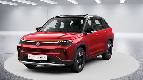 Red Maruti Suzuki Victoris SUV displayed in a showroom under bright lights, showcasing modern design and sporty styling
