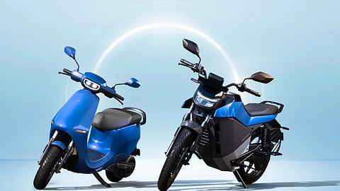 Two blue Ola electric vehicles — a scooter and a motorcycle — displayed side by side against a light blue background, symbolising India’s growing electric mobility trend.