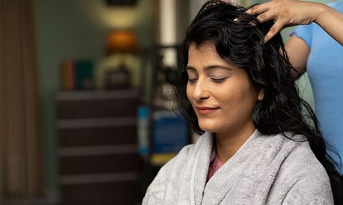 a woman massaging head of a tourist