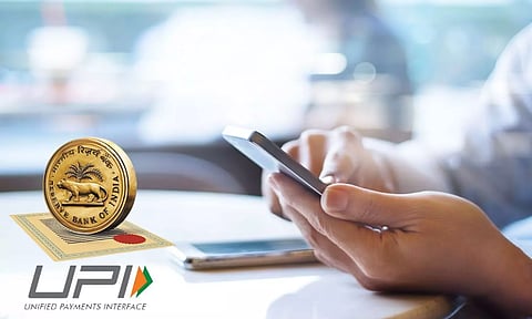 RBI logo. UPI logo, Man looks at mobilephone