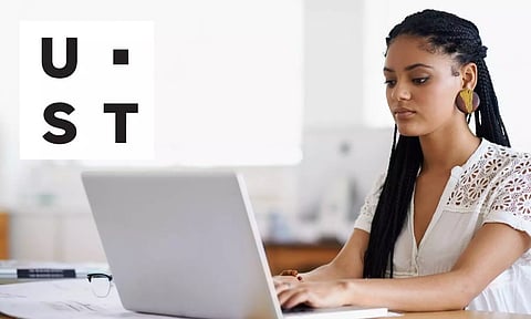 lady working on computer and ust logo
