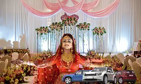 an indian bride in front of a wedding hall and few cars