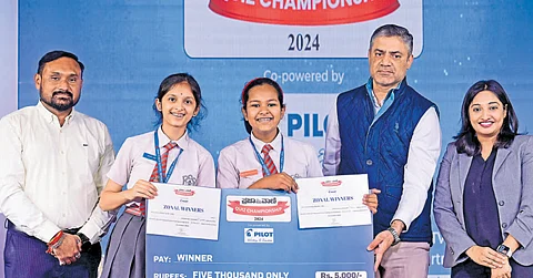 Army Public School students Niyati Jois and Rhythm Srivastava who won the B’luru zonal level ‘Prajavani’ quiz, receive the prize from Regional Business Manager of ‘Pilot Pen’ Ganesh Hegde and TPML National Sales Head Anand Bildikar. Quiz Master Meghavi Manjunath is also seen.
