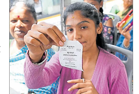 A woman displays a free ticket aboard a BMTC bus.