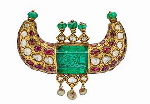 This gold pendant features a 125 carat Colombian emerald engraved in Arabic with salutations of peace. Set with diamonds, Burmese rubies, emerald beads and dangling pearls, it was made for a ruler of the Kingdom of Mysore. Mughal Era • Mysore • 18th century • emerald, ruby, diamond and pearl in 22K gold