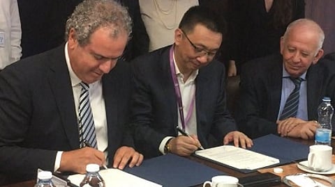 IDE President (l) Yoram Dvash and SDE President Li Qiang sign MOU, while Jacob Korn, President of IsDMA looks on. (Efi Sameach photo)