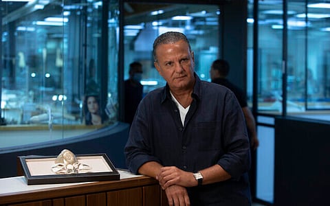 Isaac Levy, owner of Israeli jewelry company Yvel, speaks during an interview with The Associated Press, next to parts of a mask, in Motza near Jerusalem, August 9, 2020. (AP Photo/Sebastian Scheiner)