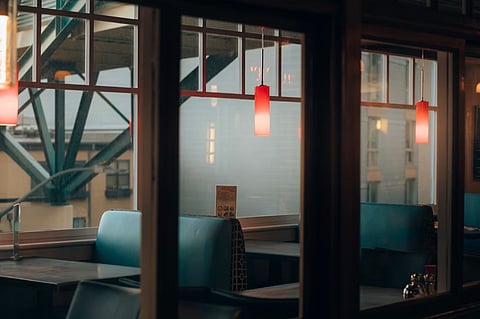 A room with a window and chairs. Photo by Josh Hild, unsplash
