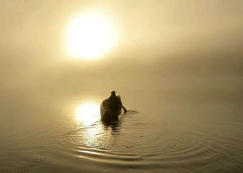 Paddling a canoe at Camp Arowhon at sunrise. Photo by Adam Waxman/DINE magazine