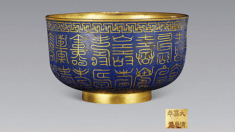 Taça de cloisonné da época do imperador Jiaqing da dinastia Qing (1796-1820), decorada com numerosas variantes caligráficas do carácter chinês para “longevidade”, simbolizando longa vida e boa sorte. Atualmente encontra-se no Museu da Província de Guangdong.