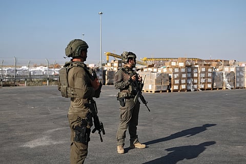 Soldados israelitas guardam paletes de ajuda humanitária, no interior da Faixa de Gaza, junto à fronteira com Israel.
