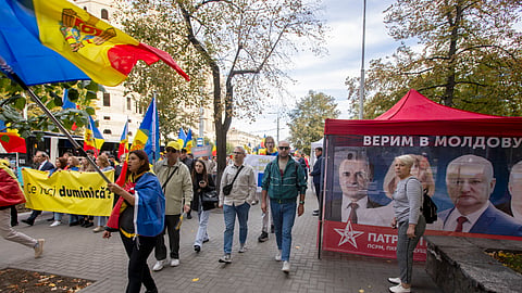 Apoiantes do PAS passam pela campanha do Bloco Patriótico no centro de Chisinau.