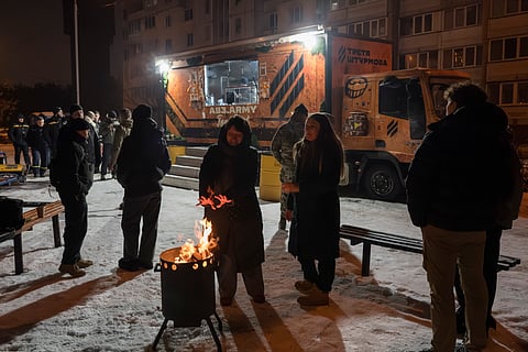 Ucranianos reúnem-se à volta de uma fogueira numa cozinha móvel em Kiev criada para ajudar quem ficou sem energia ou aquecimento após os ataques russos.