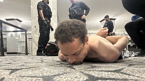 O suspeito após ser preso, numa foto divulgada por Trump.