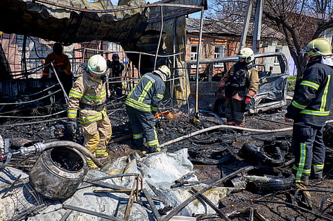 Equipas de resgate ucranianas trabalham no local de um ataque russo a uma zona residencial em Kharkiv.