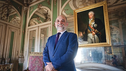Paulo Rezzutti diante do retrato de D. João VI no Palácio de Queluz.
