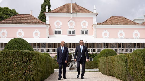 Presidente e ex-Presidente com o palácio em fundo.