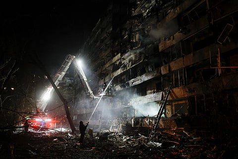 Equipas de resgate ucranianas trabalham no local de um ataque com mísseis russos contra um edifício residencial em Kiev.