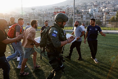 Equipas médicas transportam vítimas do ataque que atingiu um campo de futebol.