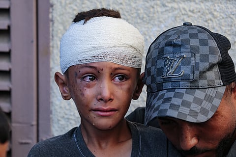 Uma criança ferida chora no pário do Hospital dos Mártires de Al-Aqsa.