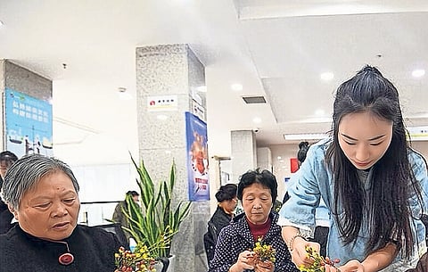 Os idosos aprendem a fazer saquinhos aromáticos da Cornus durante um evento do Festival Chongyang, realizado em outubro de 2023 em Guiyang, província de Guizhou, no sudoeste da China.