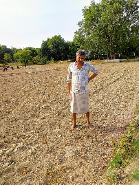 फोटो : प्रयागराज के मेंडारा गांव में सूखे खेतों में खड़े किसान फूलचंद्र मौर्य, द्वारा : आर्यन कपूर