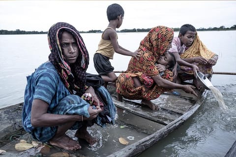 बांग्लादेश के नेत्रोकोना में बाढ़ में डूबे घरों को छोड़कर जाते बेबस। मानसून के दौरान बांग्लादेश का 70 फीसदी हिस्सा पानी में डूबा रहता है; फोटो: सुप्रतिम भट्टाचार्य/ आईस्टॉक