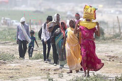 गर्मी और लू के थपेड़ों के बीच यात्रा करते लोग; फोटो: आईस्टॉक