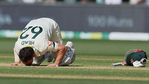 Australia's Travis Head kisses the pitch after scoring a century during play on day three of the third Ashes cricket test between England and Australia in Adelaide, Australia, Friday, Dec. 19, 2025