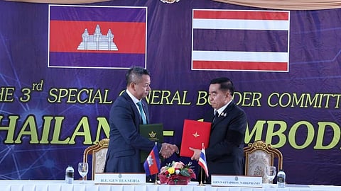 Cambodian Defense Minister Tea Seiha, left, stands with Thai Defense Minister Natthaphon Narkphanit, right, at the General Border Committee Meeting in Chanthaburi Province, Thailand