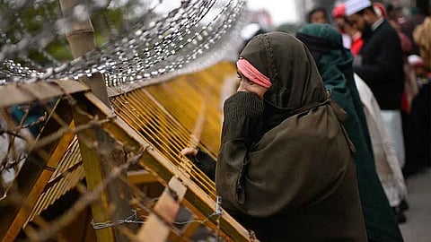 A woman reacts while waiting behind barricades outside the hospital where former Bangladeshi Prime Minister Khaleda Zia died, in Dhaka, Bangladesh.