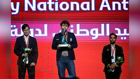 Magnus Carlsen (C), Vladislav Artemiev (L) and Arjun Erigaisi with the titles
