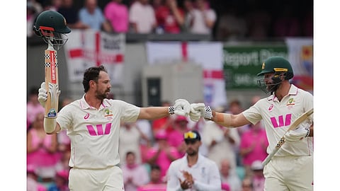 Australia's Travis Head is congratulated by teammate Michael Neser, right, after scoring a century during play on day three of the fifth and final Ashes cricket test between England and Australia in Sydney.