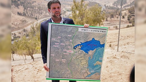 Israeli Finance Minister Bezalel Smotrich holds a map that shows the E1 settlement project during a press conference near the settlement of Maale Adumim, in the Israeli-occupied West Bank