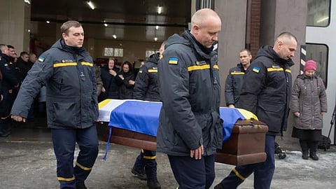 Rescuers carry the coffin of their fellow Oleksandr Zibrov, 36, who was killed in a secondary Russian drone strike on a residential building, at a fire station in Kyiv, Ukraine.