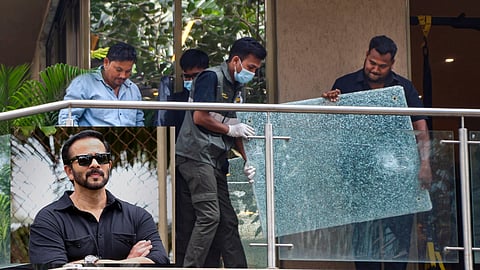 Forensic team members remove a shattered glass pane from the balcony of filmmaker Rohit Shetty