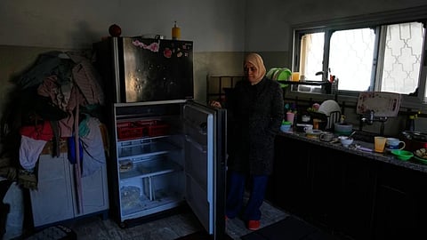 Palestinian laborer Shuhrat Barghouthi shows her empty fridge, saying that she struggles to buy food after Israel revoked work permits for Palestinians in the West Bank city of Tulkarem