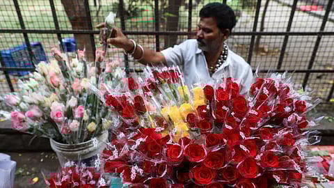 Vendor selling different colour of roses at the flower market.