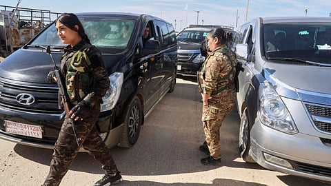 Female members of the Syrian Democratic Forces secure the area as vans carrying family members of suspected Islamic State militants who are Australian nationals head to the airport in Damascus during the first repatriation operation of the year at Roj Camp in eastern Syria, Monday, February 16, 2026. Thirty-four Australian citizens from 11 families departed the camp.