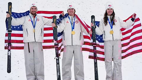 Gold medalists United States' Christopher Lillis, Connor Curran and Kaila Kuhn celebrate after the freestyle skiing mixed team aerials final at the 2026 Winter Olympics, in Livigno, Italy.