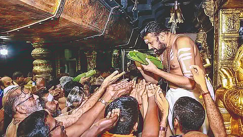 Head priest Kandararu Rajeevarau shares ‘prasad’ with
devotees at Sabarimala Ayyappa temple (file photo)
