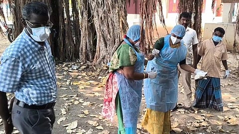 Officials examine the carcasses of birds lying dead mysteriously in Namakkal