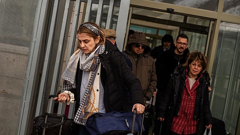 People, mostly Iranians who crossed from Iran at the Kapikoy border crossing, pull luggage in Turkey’s eastern Van province, Friday, March 6, 2026.