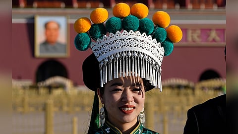 A ethnic minority delegate stand near Mao Zedong's portrait on Tiananmen Square before a plenary session of the National People's Congress (NPC) held at the Great Hall of the People in Beijing.