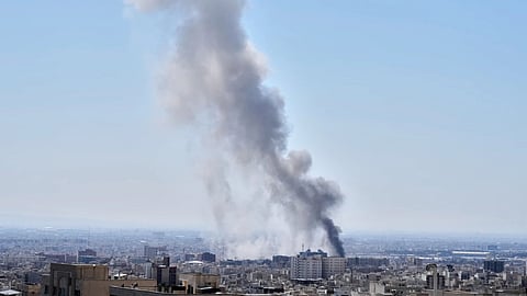 A plume of smoke rises after a strike in Tehran, Iran