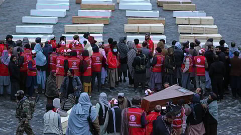 Coffins containing the remains of victims of a Monday airstrike on a drug rehabilitation hospital are laid out before burial in Kabul, Afghanistan